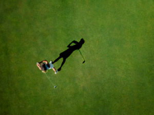 Woman playing golf on golf course Woman playing golf on golf course